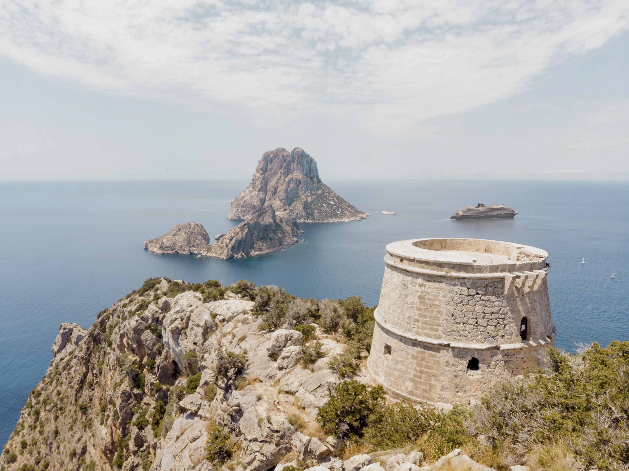 The Nature Reserve Of Es Vedra Island In Front Ibiza Coast With Watchtower Taken With Drone. El Paisaje De Ibiza Con La Isla De Es Vedra Y Torre De Vigilancia.